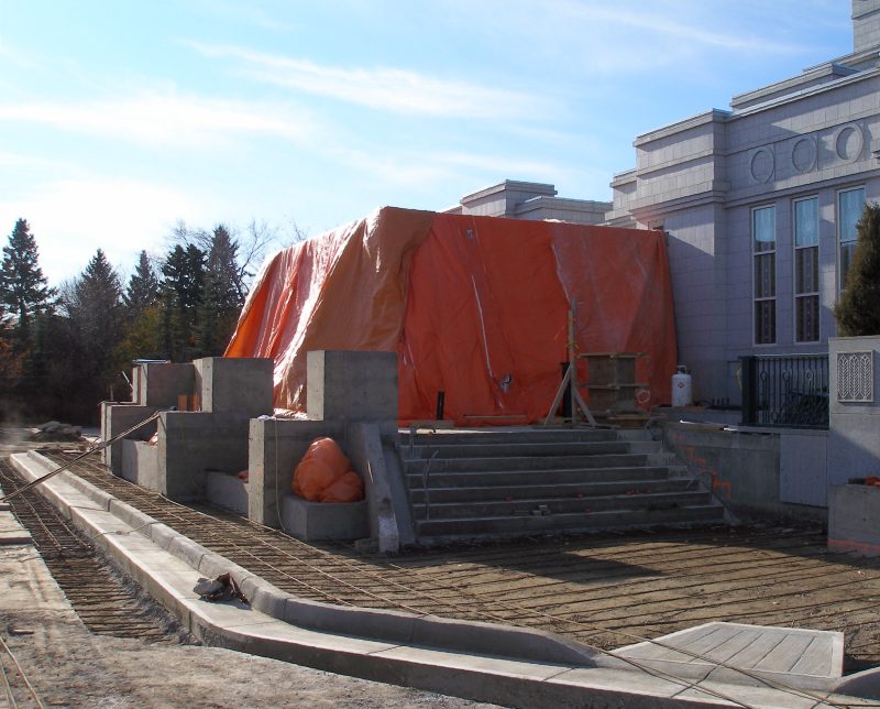 Rebar is in place for the foundations of the roadbed and the walkway. The portico is shrouded against the weather.