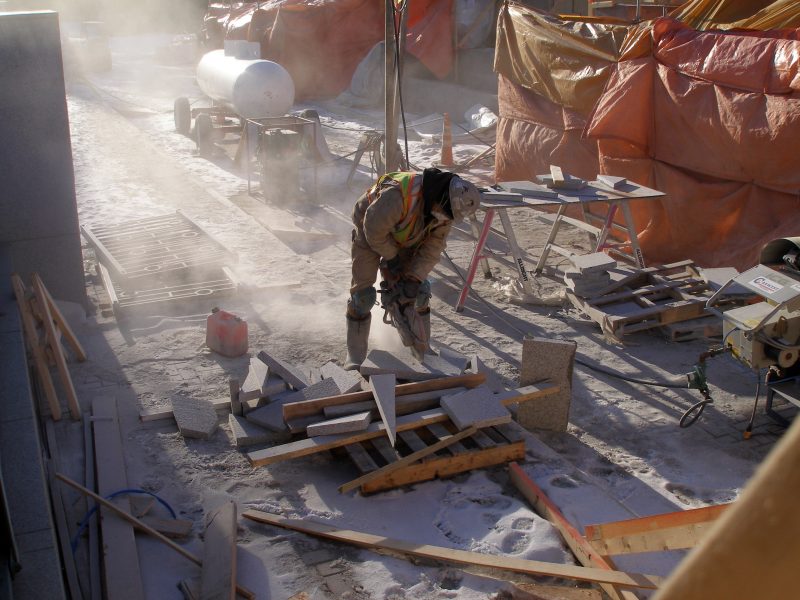 Worker cuts stone for the South stairs, planters, etc.