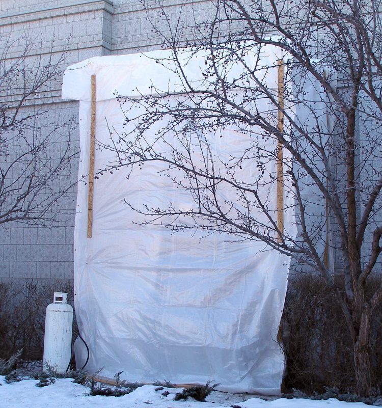 Weather protection shrouds the North window openings for final fitting and sealing.