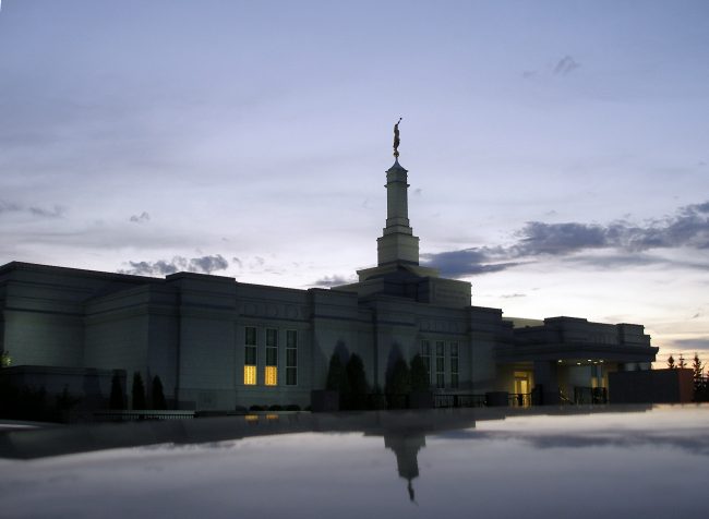 Spire with Moroni statue reflected from a car rooftop in Southeast parking lot.